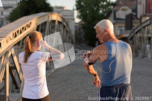 Image of jogging couple planning running route  and setting music