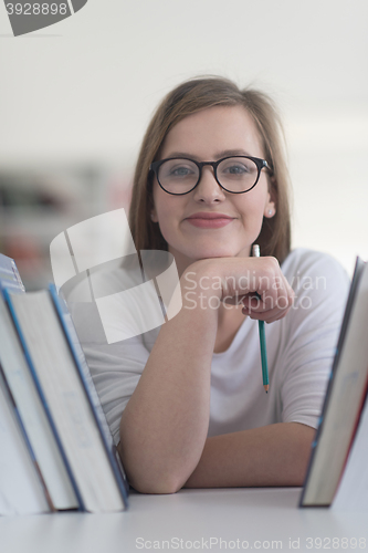 Image of portrait of famale student selecting book to read in library