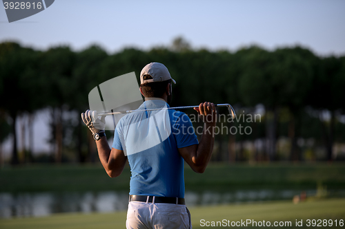 Image of golfer from back at course looking to hole in distance