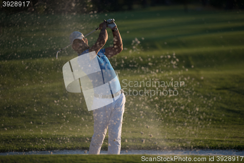 Image of golfer hitting a sand bunker shot on sunset