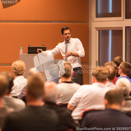 Image of Business speaker giving a talk in conference hall.
