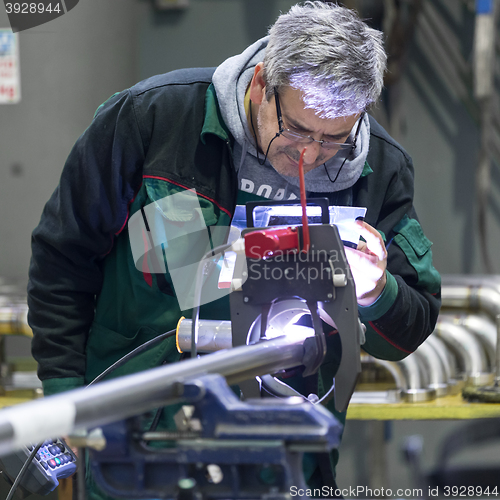 Image of Industrial worker setting orbital welding machine.