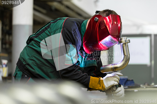 Image of Industrial worker welding in metal factory.