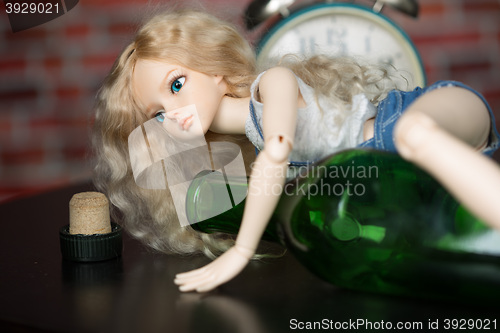 Image of doll with a bottle. the concept of alcoholism
