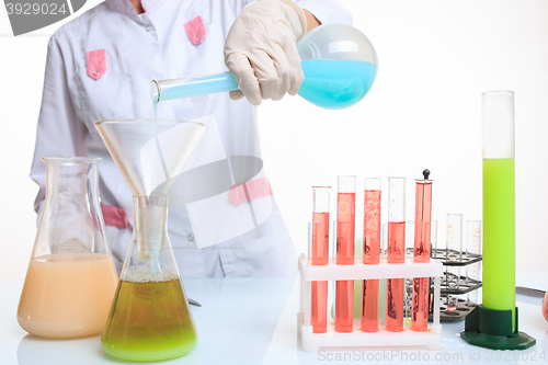 Image of hands holding test tubes with chemical elements. 