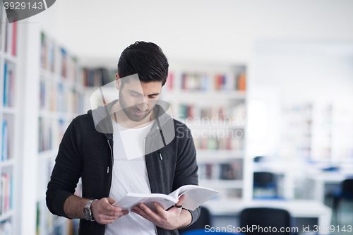 Image of portrait of student while reading book  in school library