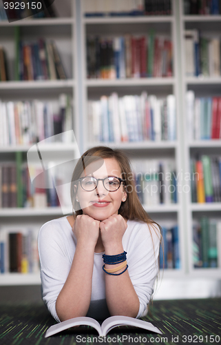 Image of female student study in library, using tablet and searching for 