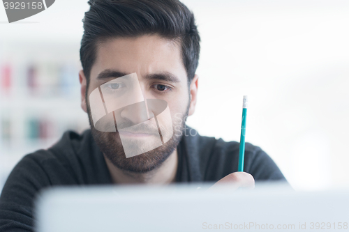 Image of student in school library using laptop for research