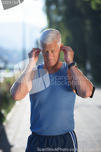 Image of portrait of handsome senior jogging man