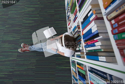 Image of female student study in library, using tablet and searching for 