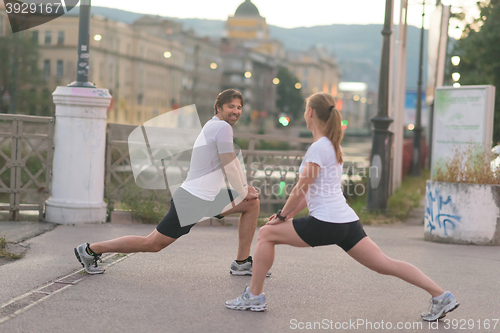 Image of couple warming up before jogging