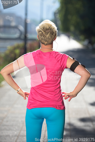 Image of jogging woman setting phone before jogging