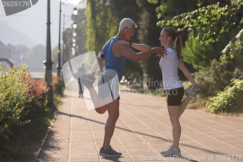 Image of couple warming up and stretching before jogging