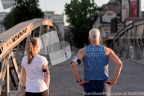 Image of jogging couple planning running route  and setting music