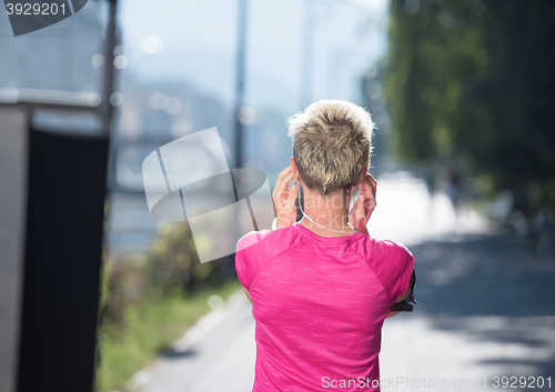 Image of jogging woman setting phone before jogging