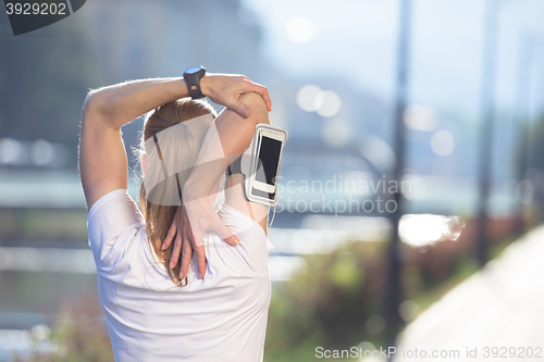Image of blonde woman  stretching before morning jogging