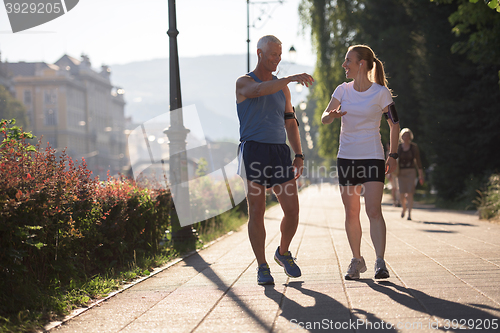 Image of jogging couple planning running route  and setting music