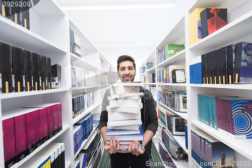 Image of Student holding lot of books in school library