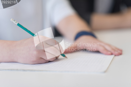 Image of male student taking notes in classroom