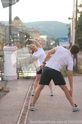 Image of couple warming up before jogging