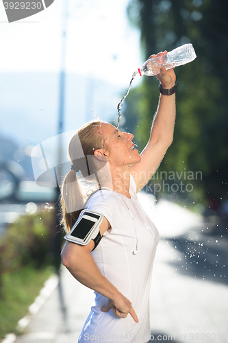 Image of woman drinking  water after  jogging