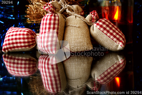 Image of Christmas decorations, gifts, candle and reflections on the glass