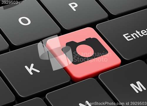 Image of Tourism concept: Photo Camera on computer keyboard background
