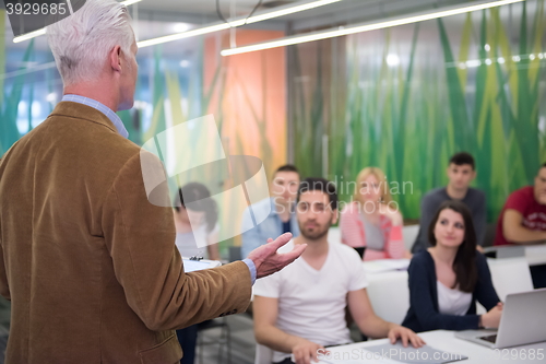 Image of teacher with a group of students in classroom