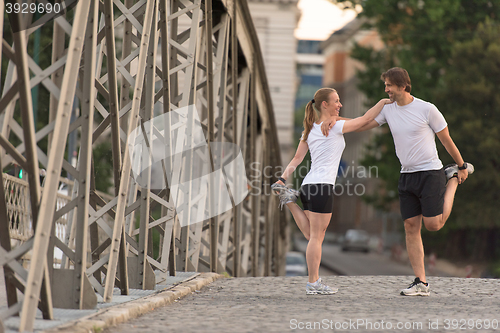 Image of couple warming up and stretching before jogging