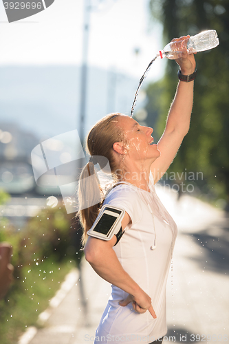 Image of woman drinking  water after  jogging