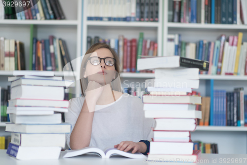 Image of female student study in library, using tablet and searching for 