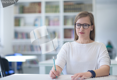 Image of famale student reading book in library