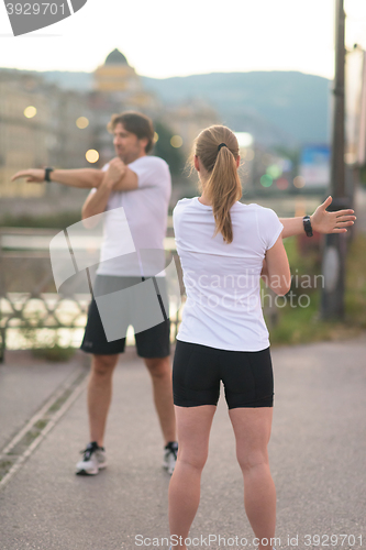 Image of couple warming up before jogging