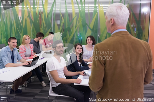 Image of teacher with a group of students in classroom