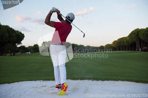 Image of golfer hitting a sand bunker shot on sunset