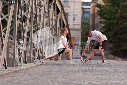 Image of couple warming up and stretching before jogging