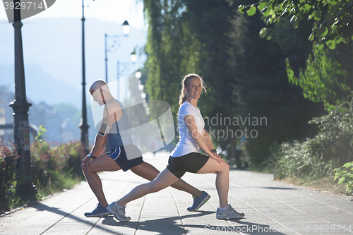 Image of couple warming up and stretching before jogging