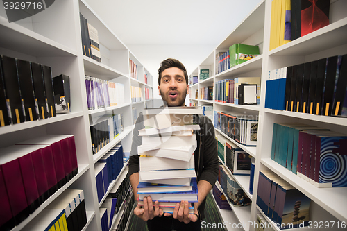 Image of Student holding lot of books in school library