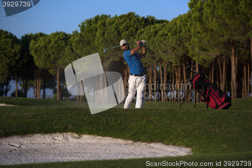 Image of golfer hitting a sand bunker shot on sunset