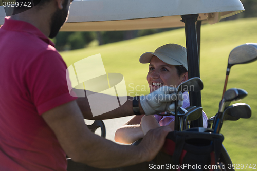 Image of couple in buggy on golf course