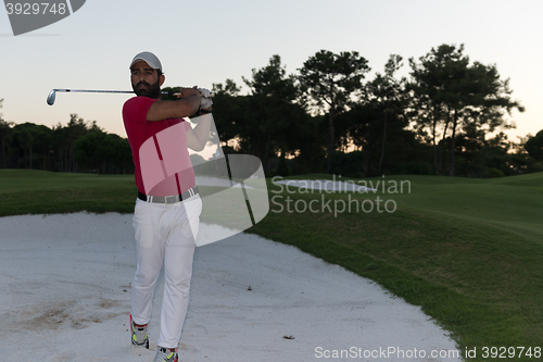 Image of golfer hitting a sand bunker shot on sunset