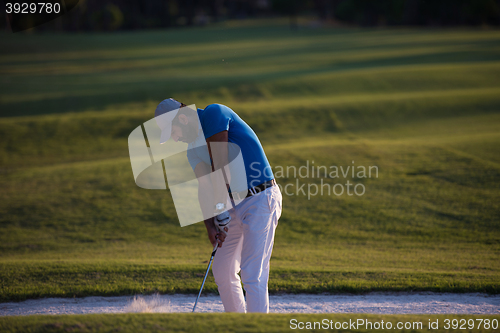 Image of golfer hitting a sand bunker shot on sunset