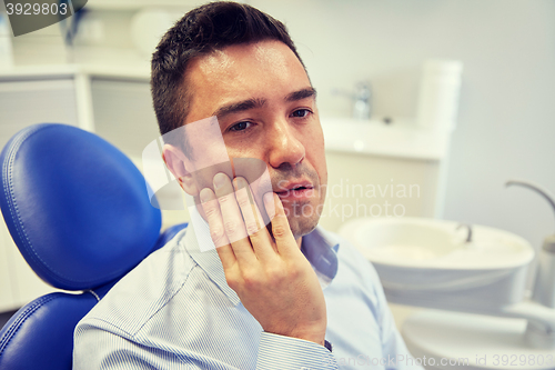 Image of man having toothache and sitting on dental chair