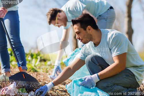 Image of volunteers with garbage bags cleaning park area