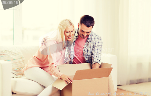 Image of happy couple with cardboard box or parcel at home