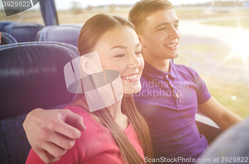 Image of happy teenage couple or passengers in travel bus