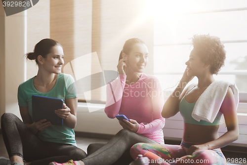 Image of happy women listening to music in gym