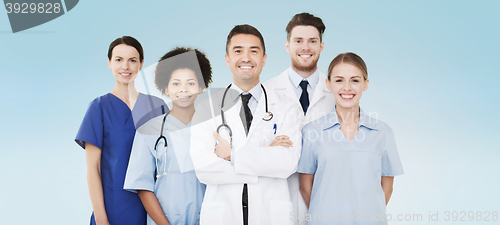 Image of group of happy doctors over blue background