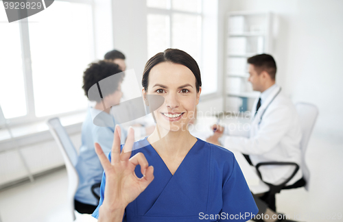 Image of happy doctor over group of medics at hospital