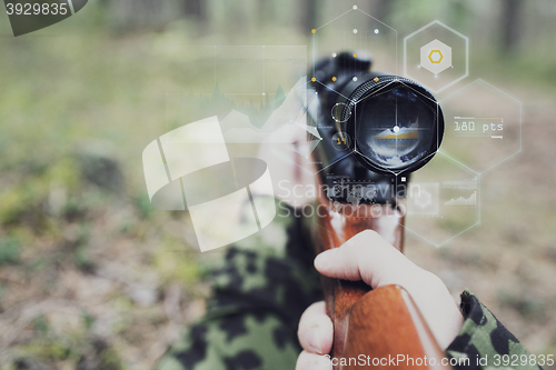 Image of close up of soldier or sniper with gun in forest